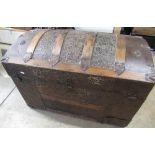 Victorian wooden banded metal covered domed topped trunk, relief decorated with trailing leafage,