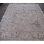 C20th wool rug, central field with stylized floral motifs surrounded by floral patterned border,