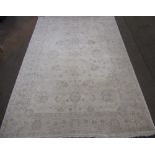 Late C20th traditional pattern wool rug, beige ground with central floral field and scrolling floral