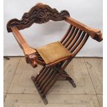 Continental Savonarola type folding chair with serpentine carved back and lions head arms on paw
