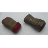 Two brass art instillations one with red leather cushion, the other in dark red leather,