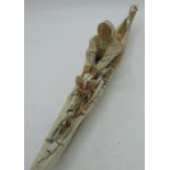 Arctic region Inuit carved model of a fisherman in Umiak open skin canoe, L47cm