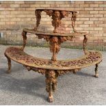 Cast iron demi-lune plant stand, three pierced graduated tiers on mask head and paw supports, W117cm