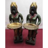 Pair of Regency style painted models of standing Blackamoors with shell trays, on square bases,