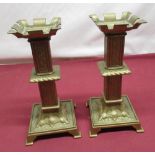 Pair of C20th cast brass candlesticks, castellated sconces on lozenge columns with acanthus square