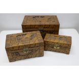 Nest of three C20th Chinese camphor rectangular boxes, deep carved with landscapes, figures in