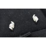 Pair of diamond stud earrings with round cut diamonds suspended in white metal mounts, 0.15ct
