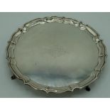 Geo.V hallmarked Sterling silver circular salver with raised Chippendale border on four hoof feet by