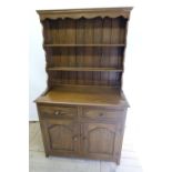 Small oak dresser, three shelf back with shaped frieze, base with two drawers above two doors