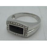 18ct white gold and diamond ring with a rectangular cabochon onyx and a halo of twenty-two round cut
