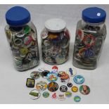 Three large glass jars full of pin badges