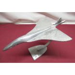 Cast aluminium model of Concorde on scroll shaped support on shaped base, overall L45cm H25cm