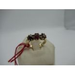 18ct yellow gold three stone garnet ring, stamped 18, I.R.T, size M, 3.9g