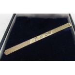 Hallmarked 9ct yellow gold engine turned tie slide inset with three brilliant cut diamonds and