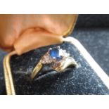 9ct yellow gold sapphire ring with an oval cut, claw set sapphire flanked by diamonds claw set in