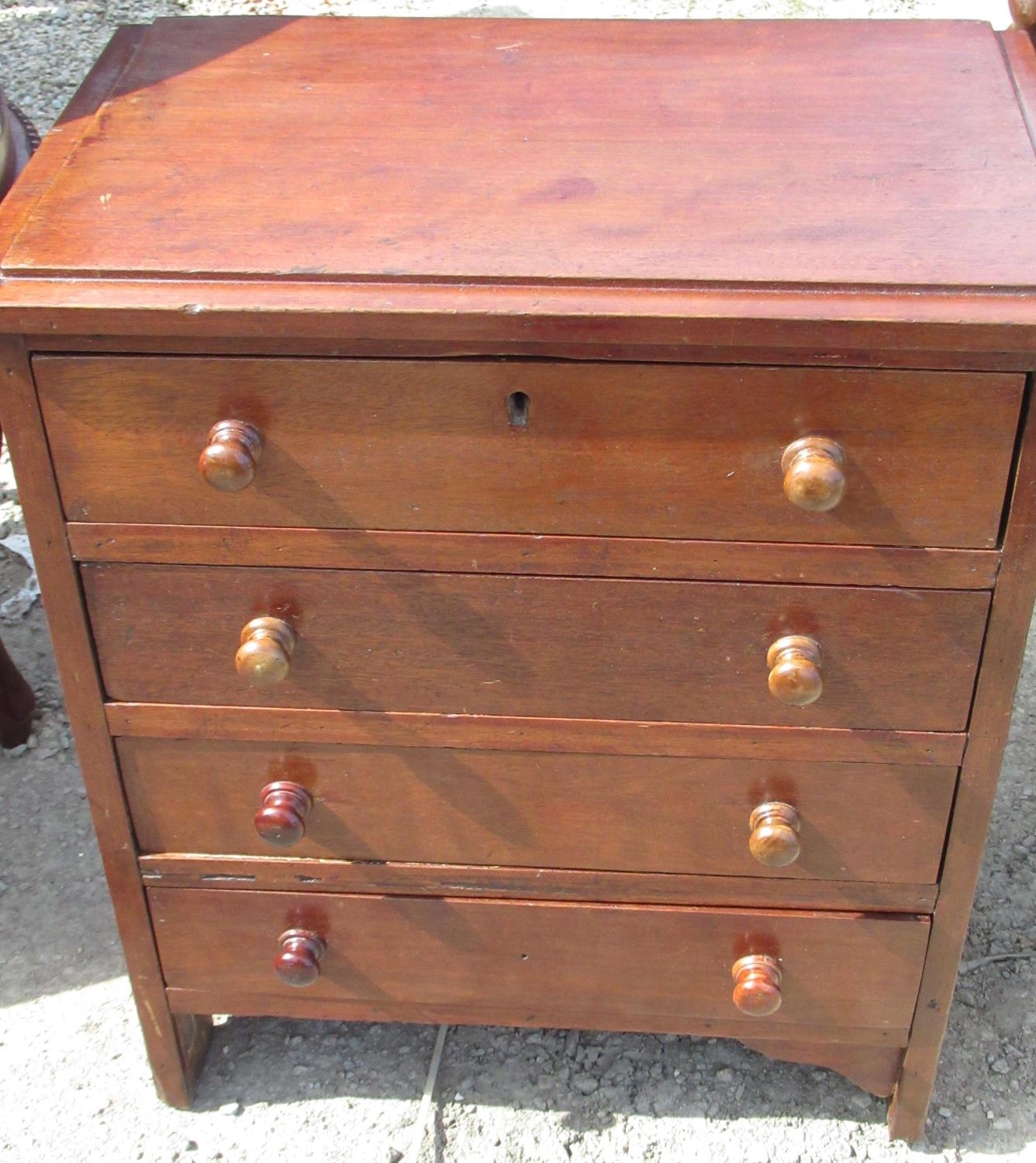 Small early C20th apprentice type mahogany chest of four drawers with turned wooden handles on