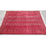 Red ground Bokhara pattern wool rug, field filled with elephant foot medallions, multi stripe