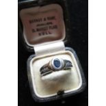 Hallmarked platinum diamond and sapphire ring, oval bezel set sapphire with four round cut channel