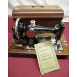 Cased vintage vibrating shuttle sewing machine, hand operated, instruction book and trade label