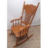 American style rocking chair with carved slat back, solid seat and downcurved arms