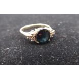 14ct gold diamond and blue stone ring with an oval cut, claw set faceted blue stone flanked by three