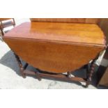 1930's oak drop leaf dining table, oval carved shaped top on barley twist and block supports