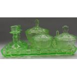 Art Deco bedroom set in green glass comprising tray, candlesticks, pin tray, and lidded jars