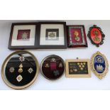 Selection of framed British military regimental cap badges with a few collar badges and shoulder
