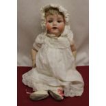 Armand Marseille model 990 bisque headed doll wearing blonde wig, white bonnet and dress with lace