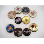 Seven Stratton compacts with floral covers, a Melissa Compact with faux wood and floral cover and