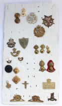 Selection of British military regimental cap badges, buttons and collar badges mounted and card plus