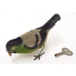 Vintage wind up mechanical bird with key.