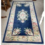 Small Chinese rectangular blue ground rug, with floral medallions and spandrels, 183cm x 93cm