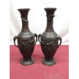 Pair of Meiji period bronze vases of baluster form, with dragon mask handles, raised detail of