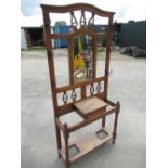 Art Nouveau style oak hall stand with central mirror above glove box with turned front supports with