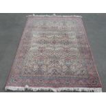 C20th Jacquard traditional pattern wool rug, pink ground with central floral pattern reserve, with