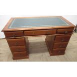 20th Century pine kneehole twin pedestal desk, with gilt tooled inset writing top three frieze and