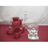 Large Cranberry glass jug, two smaller cranberry glass jugs both with shaped rim and a cranberry