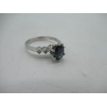 18ct white gold sapphire and diamond ring, oval cut claw set sapphire flanked by two round cut