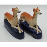 Pair of Victorian Staffordshire Greyhound pen stands, with crossed paws on gilt lined blue bases,