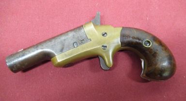 Colt Derringer pistol with brass frame and two piece wooden grip