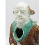 Victorian majolica jug in the form of an elderly cleric with scroll behind his back, H27.5cm, and