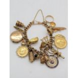 Hallmarked 9ct yellow gold charm bracelet Chester, 1902, with a collection of charms including Geo.V