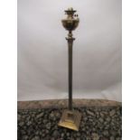 Early C20th brass floor standing oil lamp, adjustable Corinthian column on square base with four