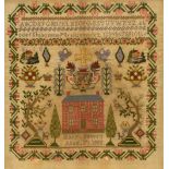 Victorian woolwork sampler worked with alphabet above house and gardens with cherubs flanking cross,