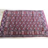 Bokhara red ground rug, field with typical medallions with hooked and geometric striped border,