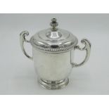 Geo.V hallmarked sterling silver twin handled cup, stepped cover with gadrooned rim and finial,