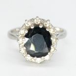 18ct white gold sapphire and diamond ring, faceted oval sapphire surrounded by a halo of inset round