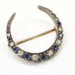 Diamond and sapphire crescent brooch, seven graduated round cut sapphires separated by eight