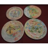 Set of four C20th glazed terracotta circular plaques or dinner plates polychrome decoration
